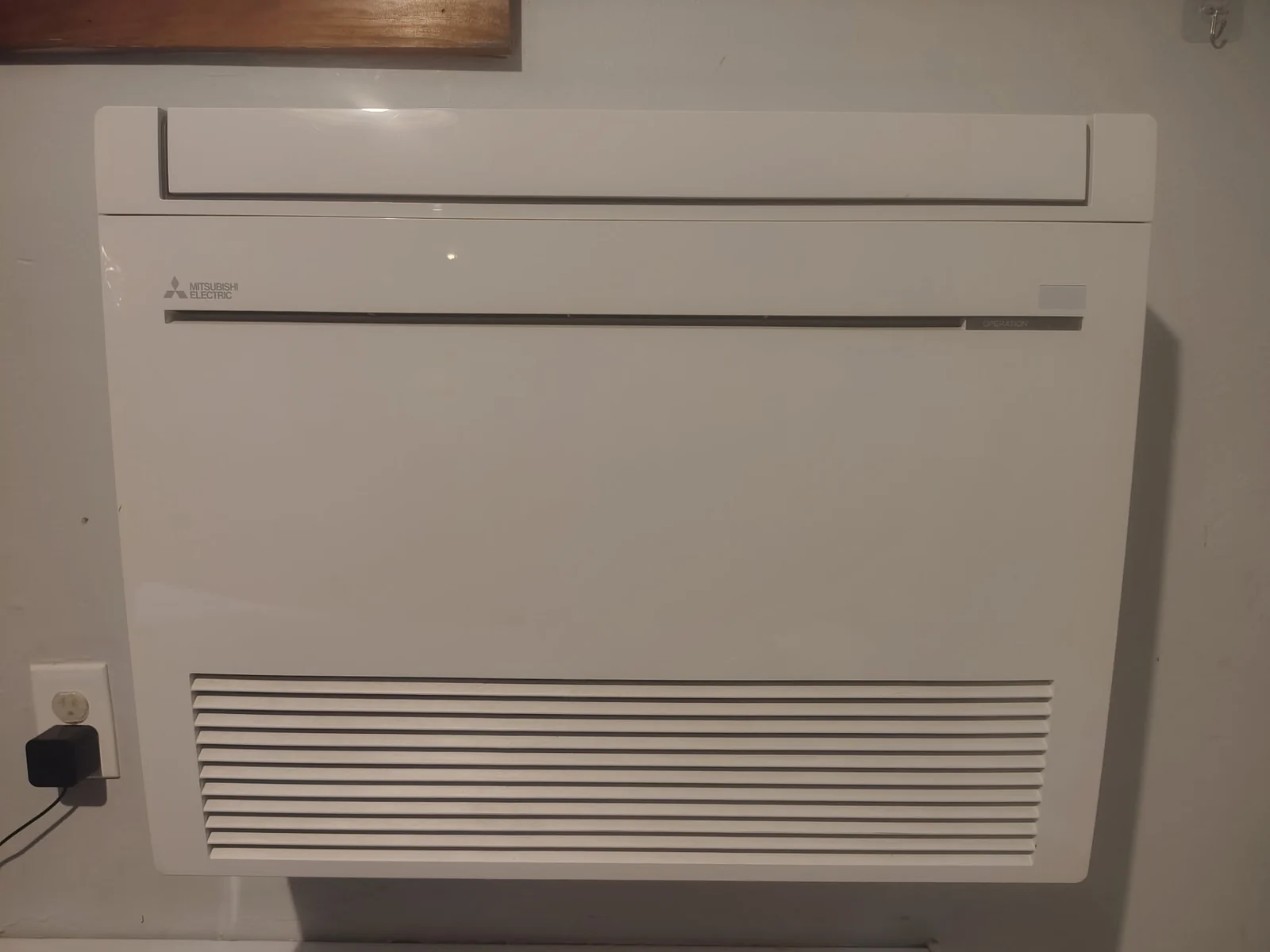 Mitsubishi Electric floor-mounted ductless mini-split indoor unit installed low on a customer's wall