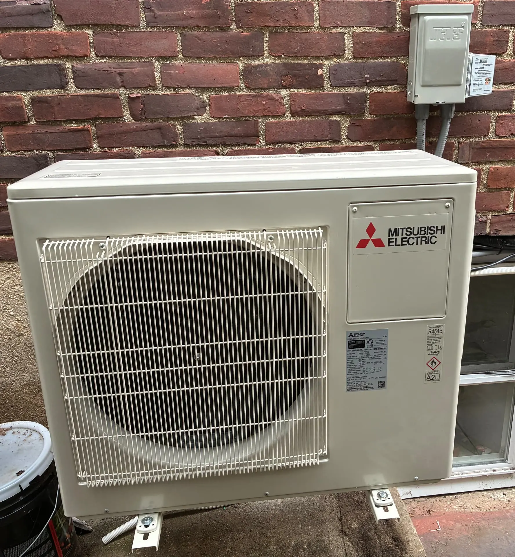 Mitsubishi Electric mini-split outdoor condenser installed beside a customer's home