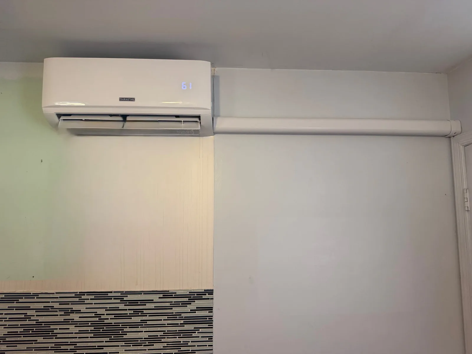 Ductless mini-split indoor head installed high on a customer's wall with tidy line cover